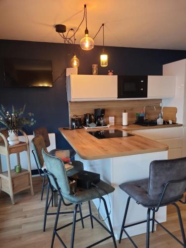 une cuisine avec un comptoir, des chaises et une table dans l'établissement Grande studio vue mer proche embarcadère, à Quiberon