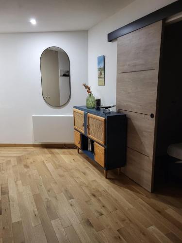 Cette chambre comprend une commode et un miroir mural. dans l'établissement Grande studio vue mer proche embarcadère, à Quiberon