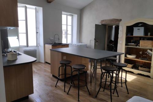 - une cuisine avec une table et quelques tabourets de bar dans l'établissement Nice T3 with Wifi near the harbor - 2 stars, à Saint-Martin-de-Ré