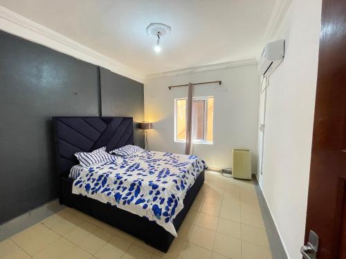una camera da letto con un letto con un piumone blu e bianco di Sweetpiol a Yaoundé