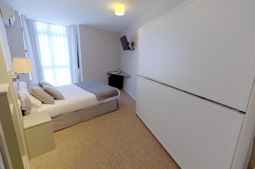a small bedroom with a bed and a window at Hostal Gran Vía in Pinto