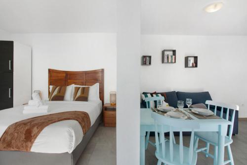 Un dormitorio con una cama y una mesa con platos. en Original Wave House, en Jardim do Mar