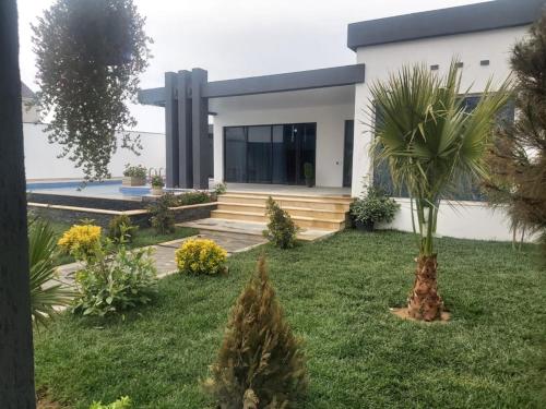 a house with a palm tree in the front yard at Villa Mayak in Baku