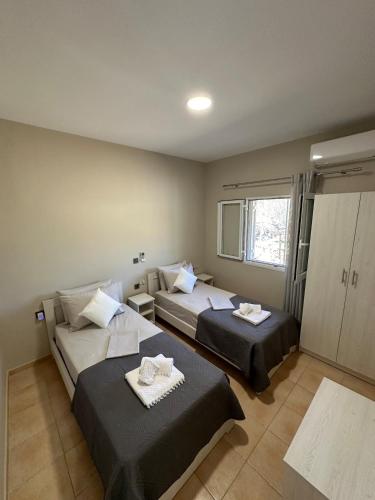 a hotel room with two beds and a window at Villa Nicole in Katarrákhion