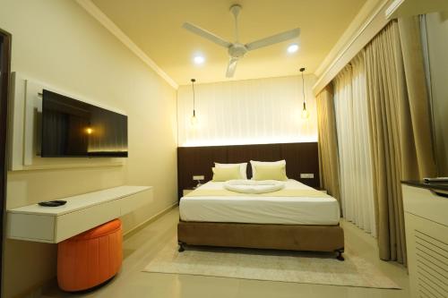 a bedroom with a bed with a desk and a window at Hotel Grand Amanee in Ratnapura
