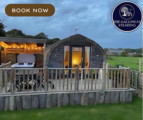 a small cabin with a porch and a fence at The Galloway Steading- The Bee Hive Couples Retreat with Hot Tub and Fire Pit in Glenluce