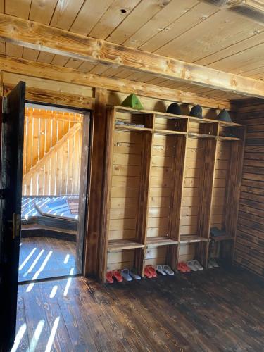 a room with wooden walls and shelves in a cabin at Під Явором in Vorokhta