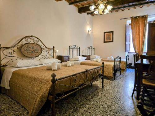 a bedroom with two beds and a table and chairs at Stay in the heart of Pisa at Dietro al Corso in Pisa
