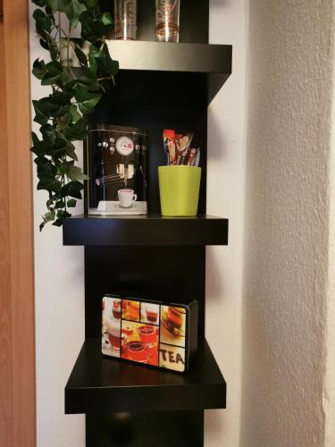a black shelf with a clock and a book at Ferienwohnung Blumen in Radeberg