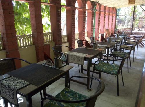 uma fila de mesas e cadeiras num restaurante em Magpie Villa em Jaipur