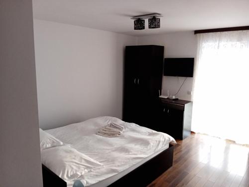 a bedroom with a bed and a black cabinet at Pensiunea Dimitrie in Mănăstirea Humorului