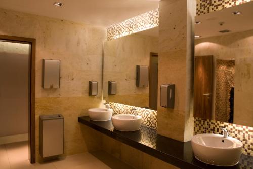 a bathroom with two sinks and a large mirror at Mercure Warszawa Airport in Warsaw