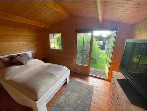 OderbergにあるFerienhaus Garten und Pool Ferienwohnung und Gästehausのベッドと大きな窓のある寝室