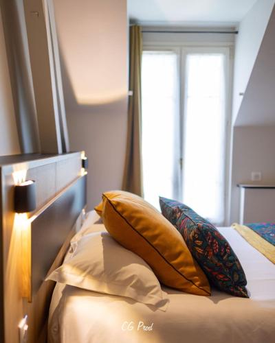 a bedroom with a bed with pillows and a window at Hotel Beau Site - Rocamadour in Rocamadour