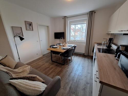 ein Wohnzimmer mit Tisch und eine Küche mit Couch in der Unterkunft for 4 - parking space for car - Internet in Bielefeld