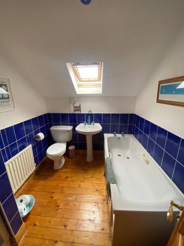 a bathroom with a tub and a toilet and a sink at Sunny Seaside Getaway in Portstewart
