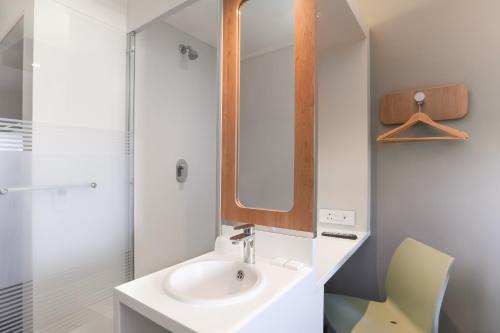 a bathroom with a sink and a mirror at SUN1 MILNERTON in Cape Town