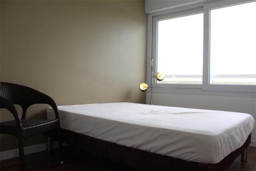 Ce lit se trouve dans un dortoir doté d'une chaise et d'une fenêtre. dans l'établissement Appt 2 pièces LA ROCHELLE - LR380-027, à La Rochelle