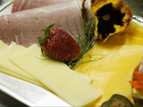 a strawberry sitting on top of a piece of cheese at Sea Whisper Guest House in Jeffreys Bay