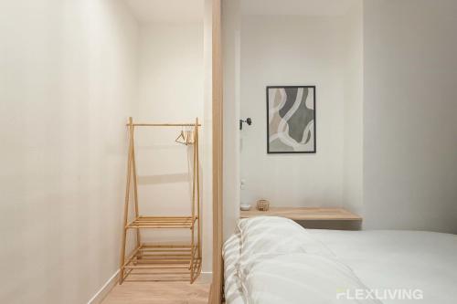 - une chambre avec un lit et une étagère en bois dans l'établissement Flexliving - Studio - La Fayette, à Paris