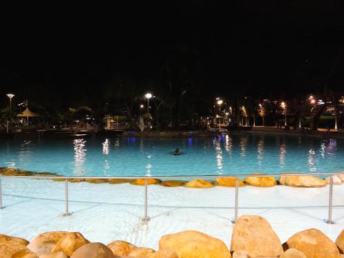 a swimming pool at night with a person swimming in it at Best Western Airport 85 Motel in Brisbane
