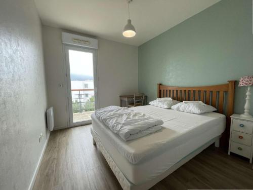 une chambre avec un grand lit et une fenêtre dans l'établissement Appt 3 pièces LA ROCHELLE - LR040-307, à La Rochelle