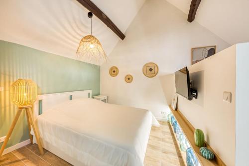 une chambre avec un lit blanc et une télévision dans l'établissement Green lime, à Carrières-sous-Poissy