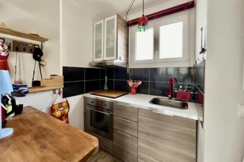 une cuisine avec un évier et un plan de travail dans l'établissement T2-4 pers-terrasse - 200m mer, à Six-Fours-les-Plages