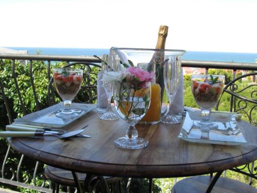 a wooden table with wine glasses and flowers on it at Sea Whisper Guest House in Jeffreys Bay