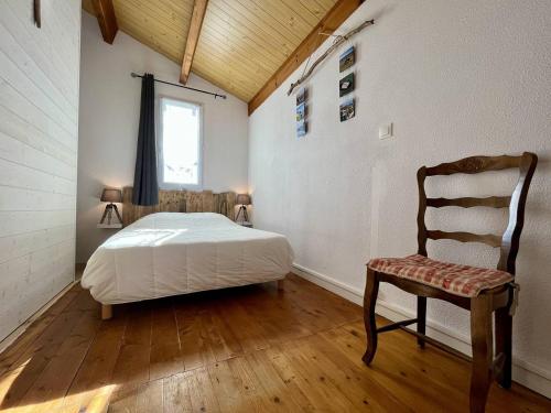 une chambre avec un lit, une chaise et une fenêtre dans l'établissement Maison 4 pièces 6 couchages Saint Pierre d'Oléron SPO000-122, à Saint-Pierre-dʼOléron