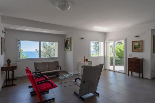 a living room with a couch and red chairs at Villa Elvise - YourPlace Abruzzo in Fossacesia