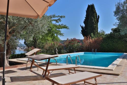 a swimming pool with two chairs and an umbrella at Villa Elvise - YourPlace Abruzzo in Fossacesia