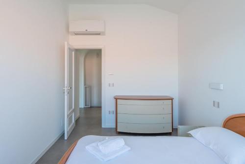 a white bedroom with a bed and a dresser at Villa Elvise - YourPlace Abruzzo in Fossacesia