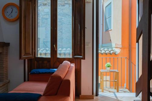 a living room with a couch and a clock on a window at La casetta di Nonna Nice - YourPlace Abruzzo in Rocca San Giovanni