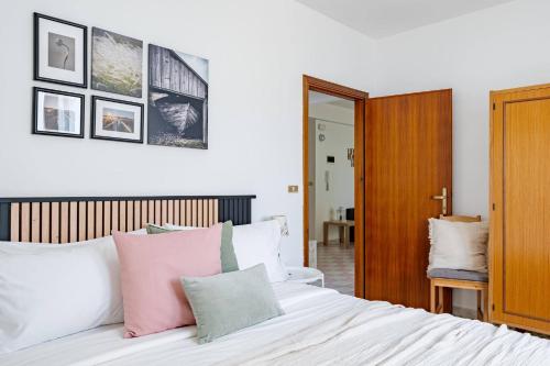 a bedroom with a white bed with pink and green pillows at Appartamento Venere - YourPlace Abruzzo in Fossacesia