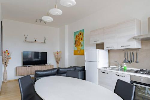 a kitchen and living room with a white table and chairs at Fronte Mare Pescara - YourPlace Abruzzo in Pescara