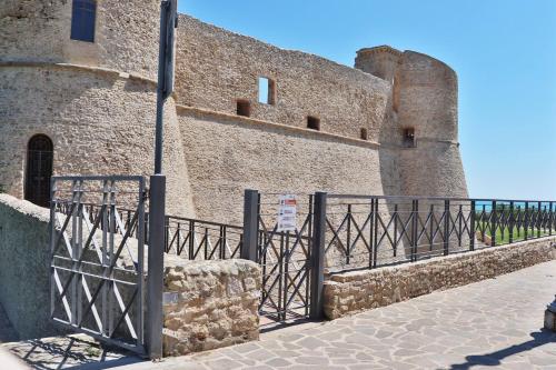 a fence in front of a large brick building at Gianna's House - YourPlace Abruzzo in Ortona