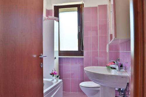 a pink bathroom with a sink and a toilet at Gianna's House - YourPlace Abruzzo in Ortona
