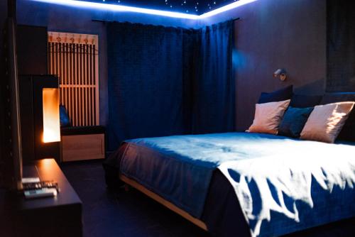 a bedroom with a bed with blue lights on it at Noctis Amoris Suite Atypique Maizeret in Samson
