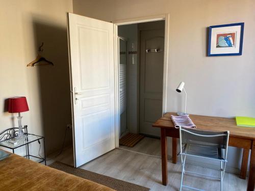 Cette chambre comprend un bureau et une table avec une chaise. dans l'établissement CALME , PROCHE du Centre, Grande Terrasse, Petit déjeuner, à Bordeaux