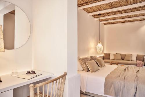 a living room with a bed and a table at Dionysos Seaside Resort Ios in Mylopotas