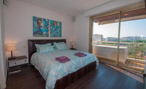 une chambre avec un grand lit et une grande fenêtre dans l'établissement Croisette - 2 Bedrooms - Panoramic sea view, à Cannes