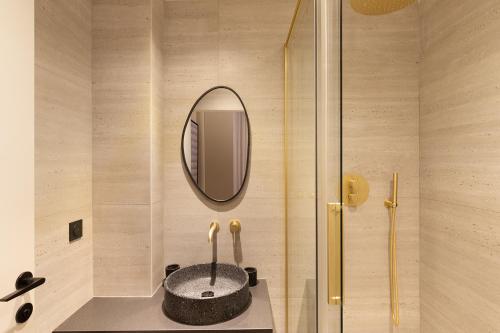 une salle de bain avec un lavabo et un miroir au mur dans l'établissement Pick A Flat's Apartment in Montmartre - Rue des Martyrs, à Paris