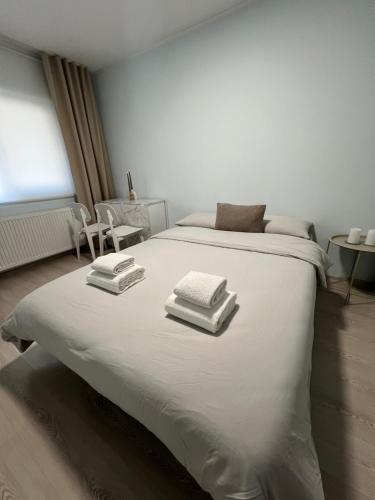 a white bed with three towels on top of it at Apart Canada Center in Baia Mare