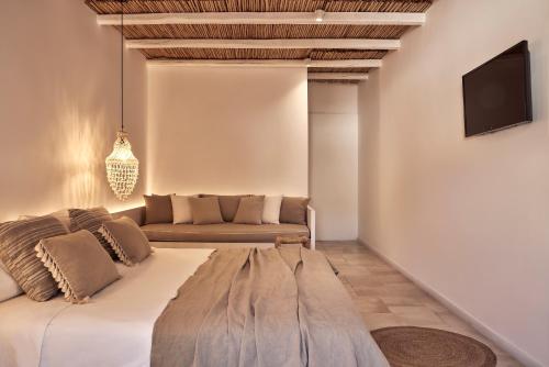a living room with a large bed and a couch at Dionysos Seaside Resort Ios in Mylopotas