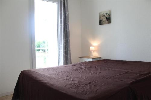 a bedroom with a bed and a window with a lamp at Appt 2 pièces LA ROCHELLE - LR030-E116 in La Rochelle