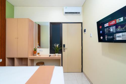 a room with a monitor on the wall and a desk at Grand Valora Puspowarno Kostel in Kalibanteng-lor