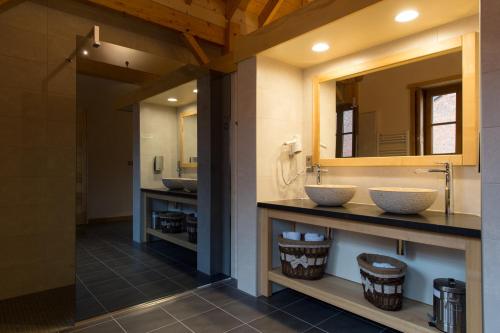 une salle de bain avec deux lavabos et un miroir dans l'établissement Auberge De L'abbaye, à Signy-lʼAbbaye
