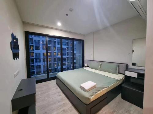 a bedroom with a bed and a desk and a window at The Base海景网红顶层无边泳池 双卧室套房 in Pattaya Central