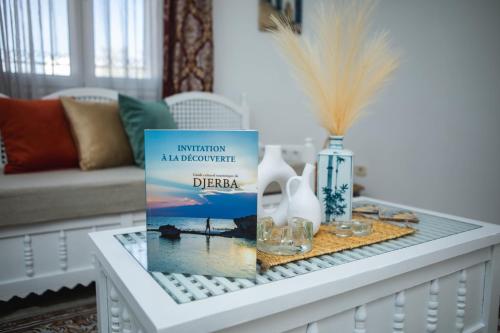 a coffee table with a book on top of it at Villa Bianca - à 10 min de la plage in Fafou